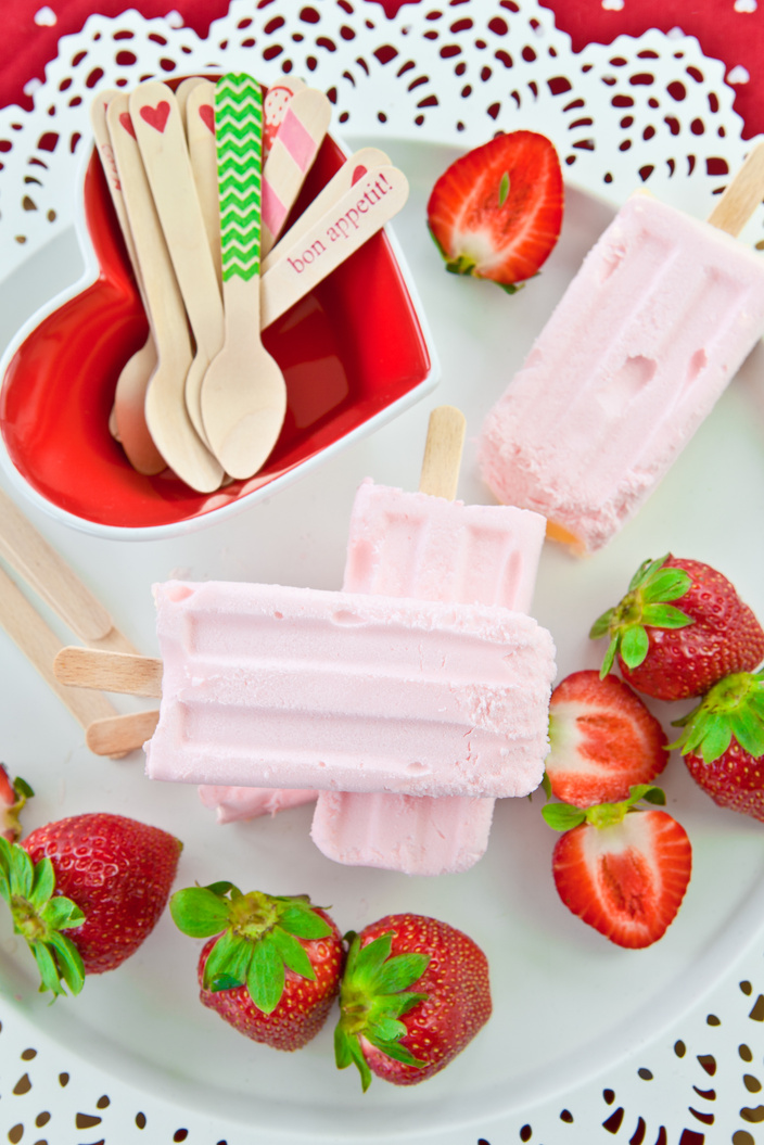 Homemade strawberry popsicles and fresh strawberries