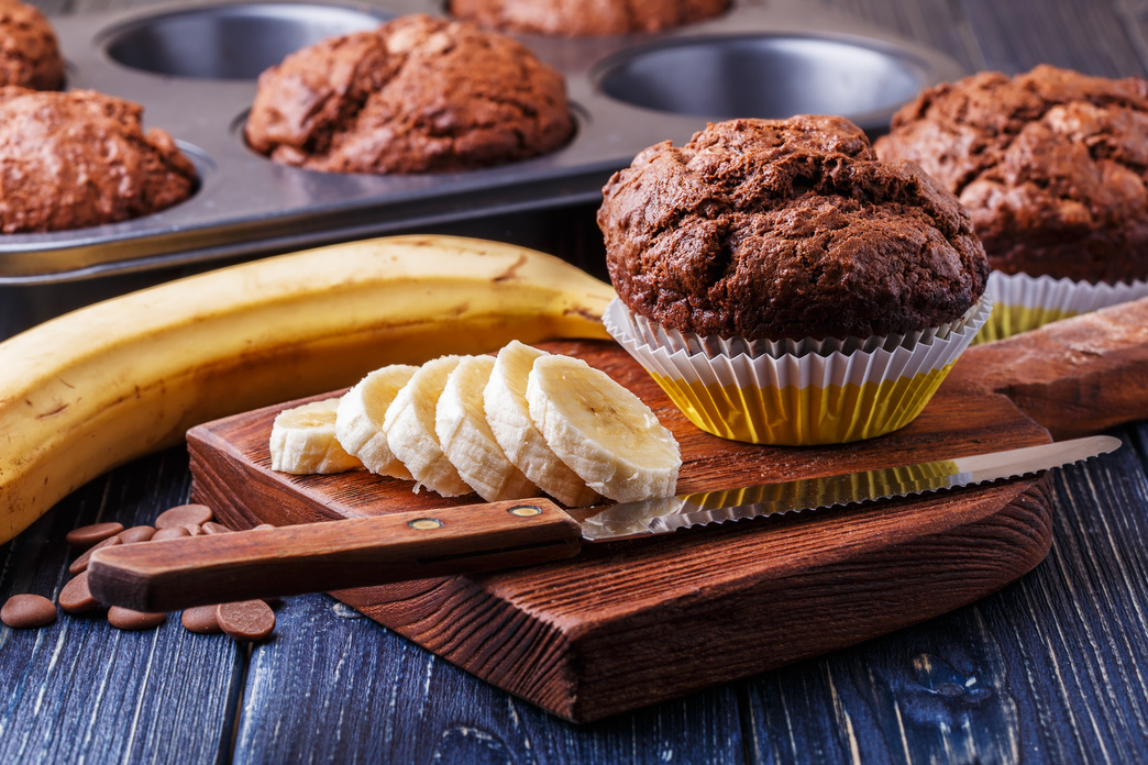 Chocolate muffins with banana on dark background.